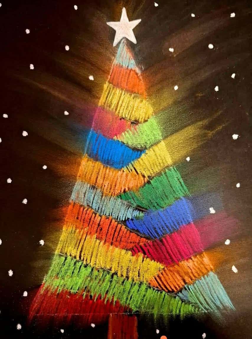 Kolorowa choinka namalowana pastelami na czarnym tle z gwiazdą na czubku i białymi płatkami śniegu.
